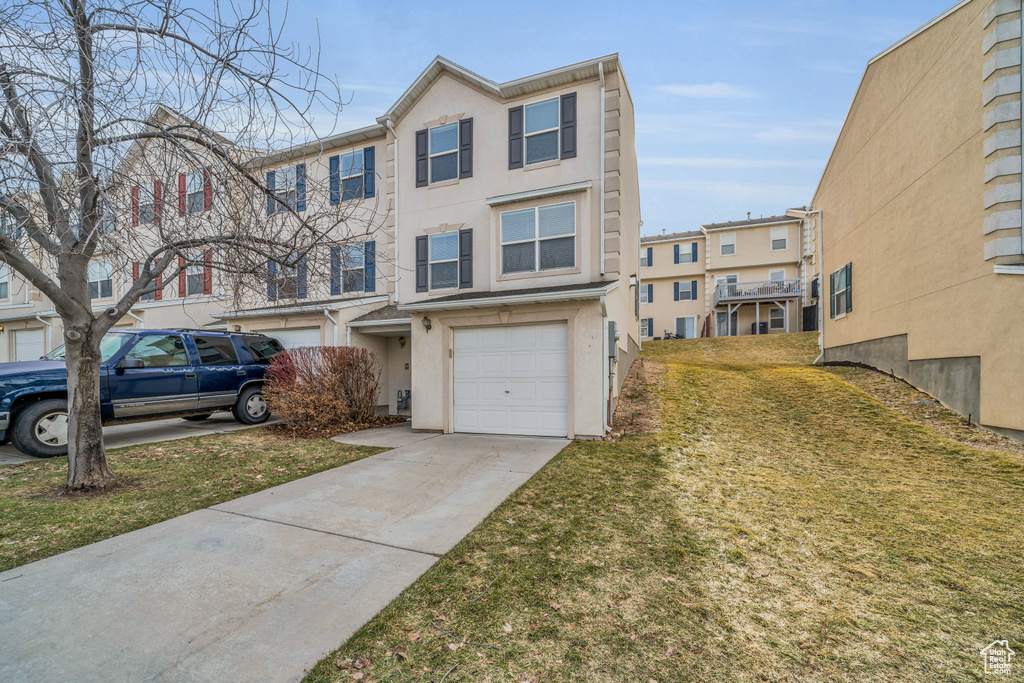 View of property featuring a garage and a front yard