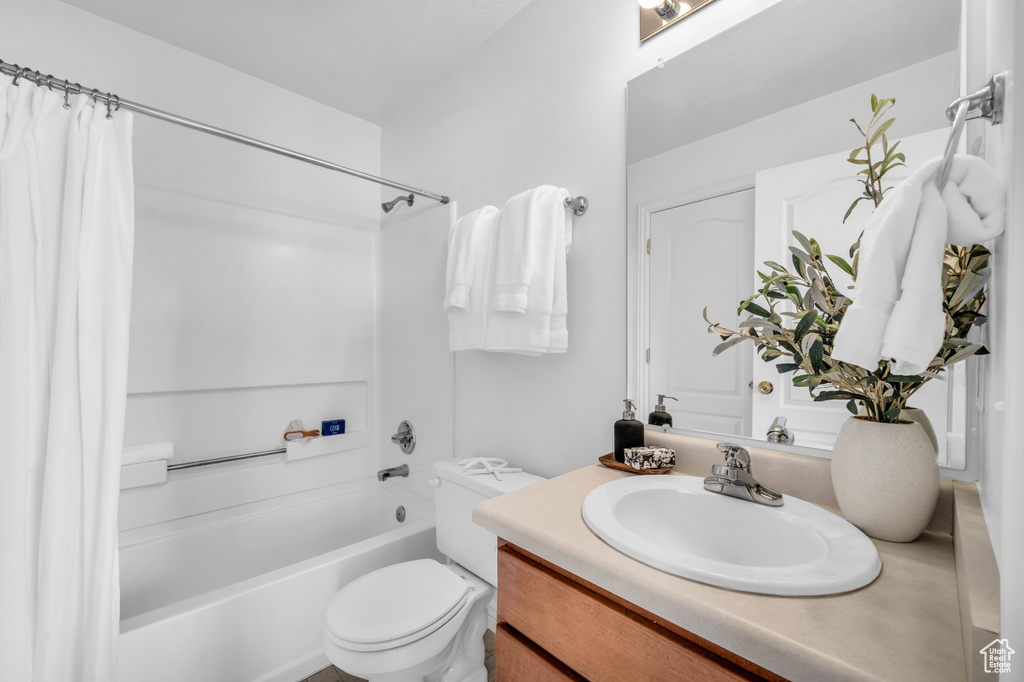 Full bathroom with vanity, toilet, and shower / tub combo with curtain