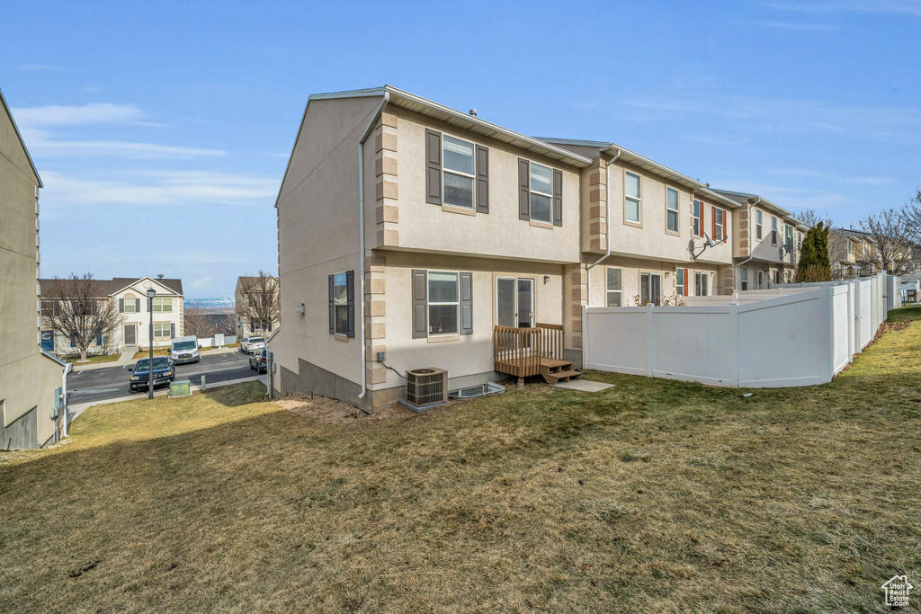 Back of property featuring a yard and central air condition unit