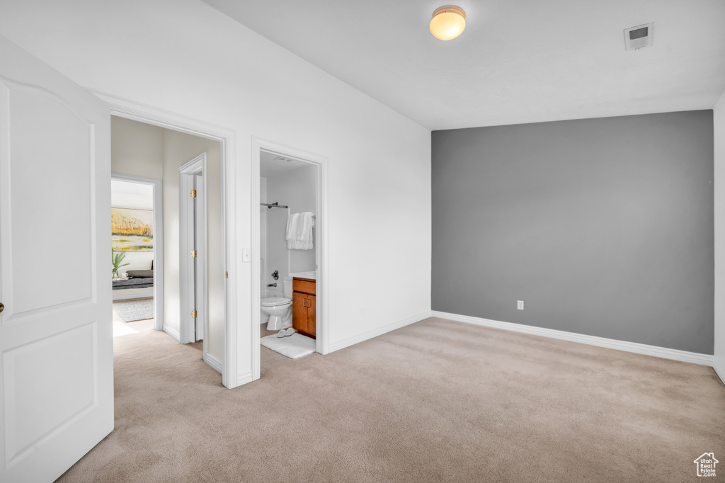 Interior space with light colored carpet and ensuite bathroom