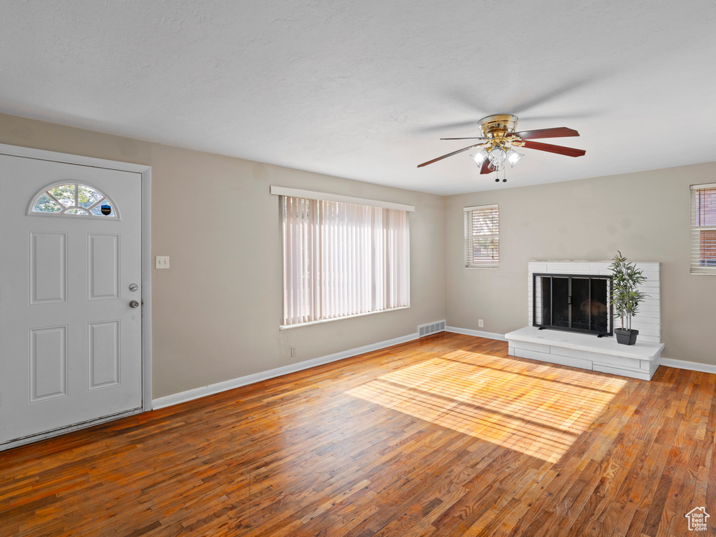 Unfurnished living room with light hardwood / wood-style floors and ceiling fan