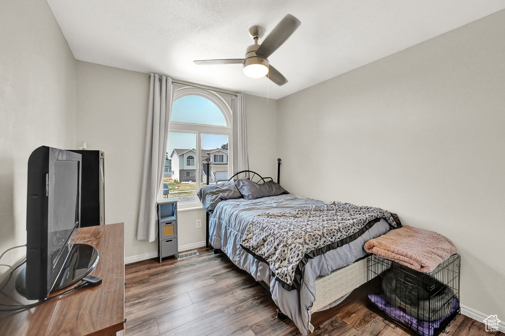 Bedroom featuring dark hardwood / wood-style flooring and ceiling fan