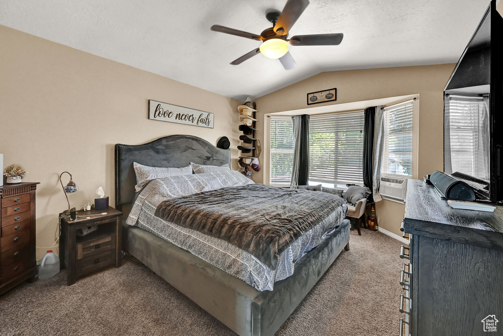 Carpeted bedroom featuring cooling unit, ceiling fan, and lofted ceiling