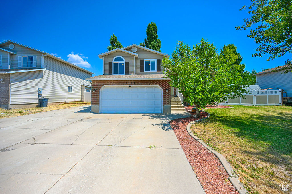 View of front facade with a garage and a front lawn