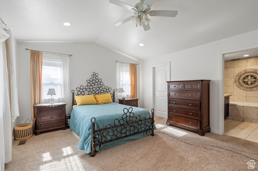 Carpeted bedroom with ensuite bathroom, ceiling fan, and vaulted ceiling