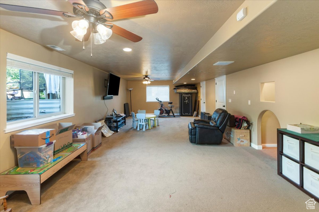 Interior space featuring light colored carpet and ceiling fan