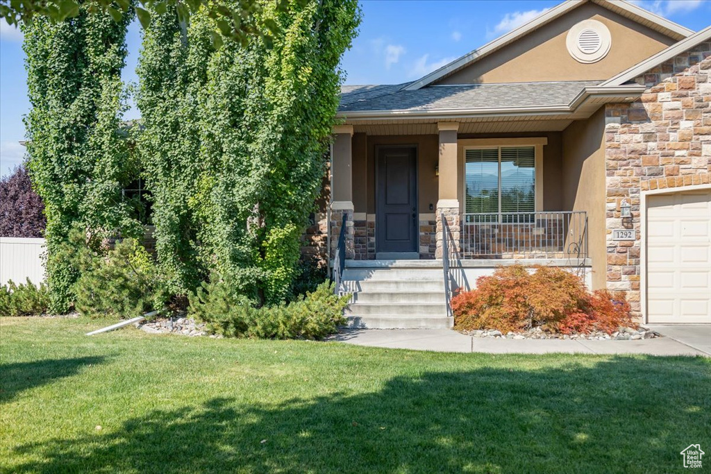 View of front of property with a porch and a front yard