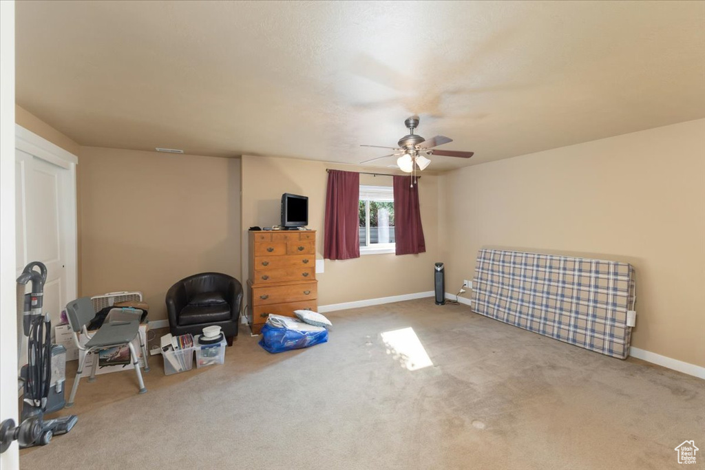 Interior space featuring light carpet and ceiling fan