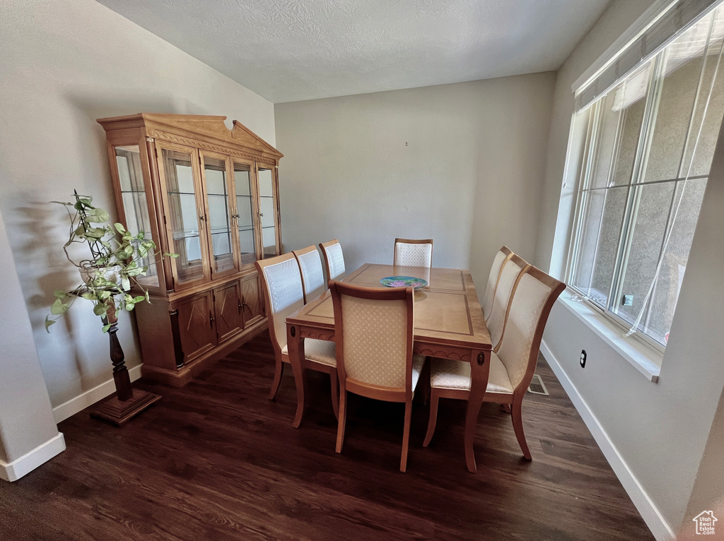 Dining area with hardwood / wood-style flooring and a textured ceiling