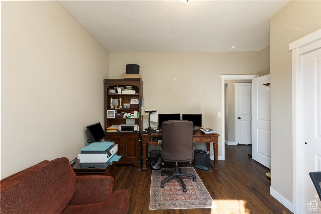 Office with dark wood-type flooring