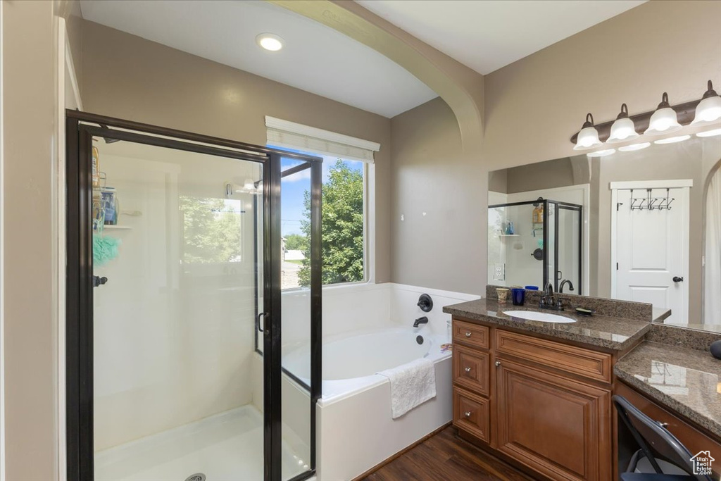 Bathroom featuring vanity, shower with separate bathtub, and hardwood / wood-style flooring