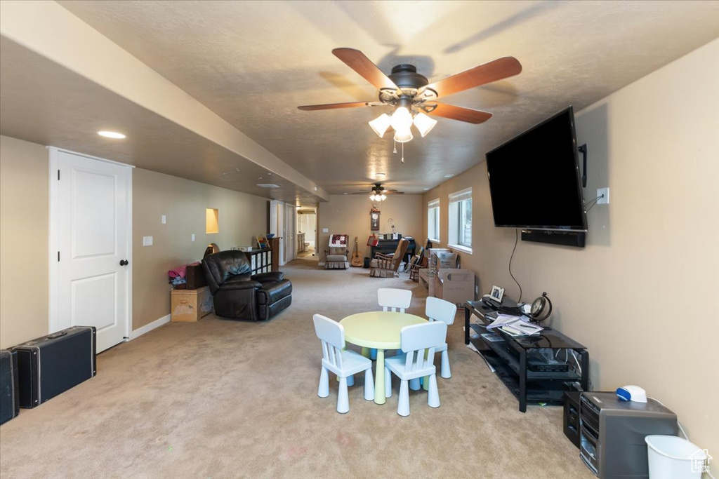 Interior space with a textured ceiling, light colored carpet, and ceiling fan