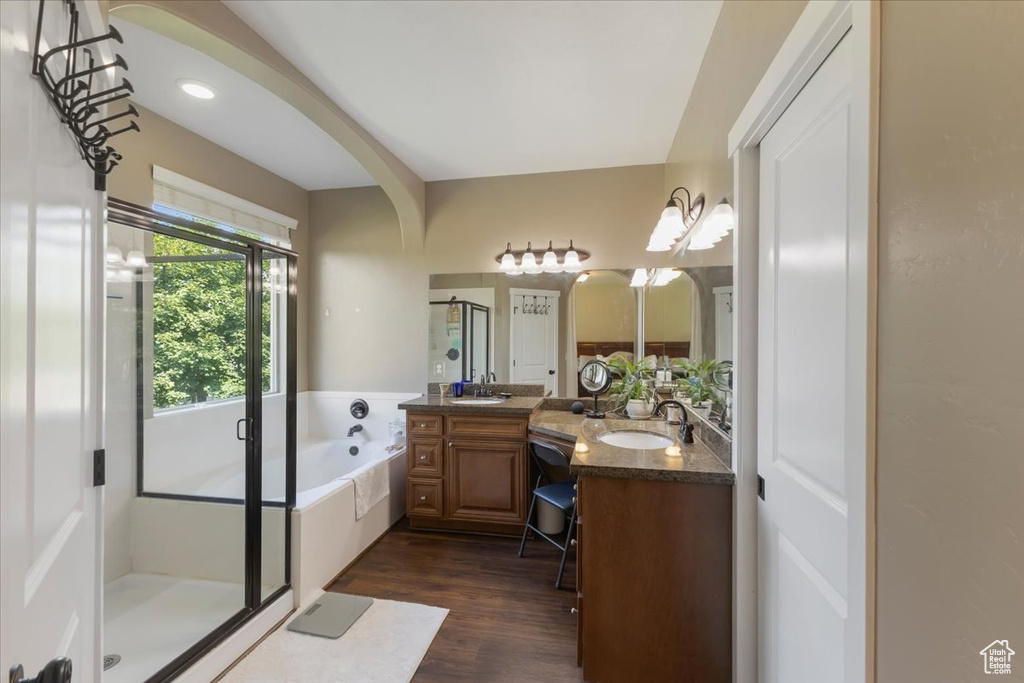 Bathroom featuring double vanity, hardwood / wood-style floors, and separate shower and tub