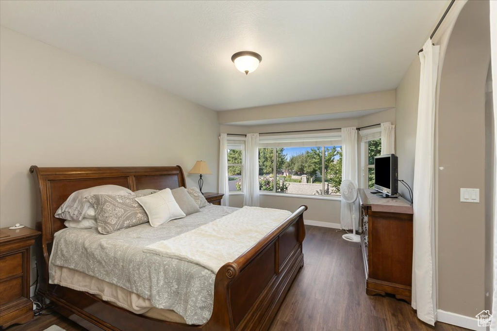 Bedroom with dark hardwood / wood-style flooring