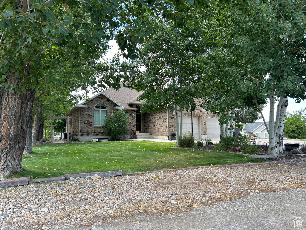 View of front of house with a garage and a front lawn