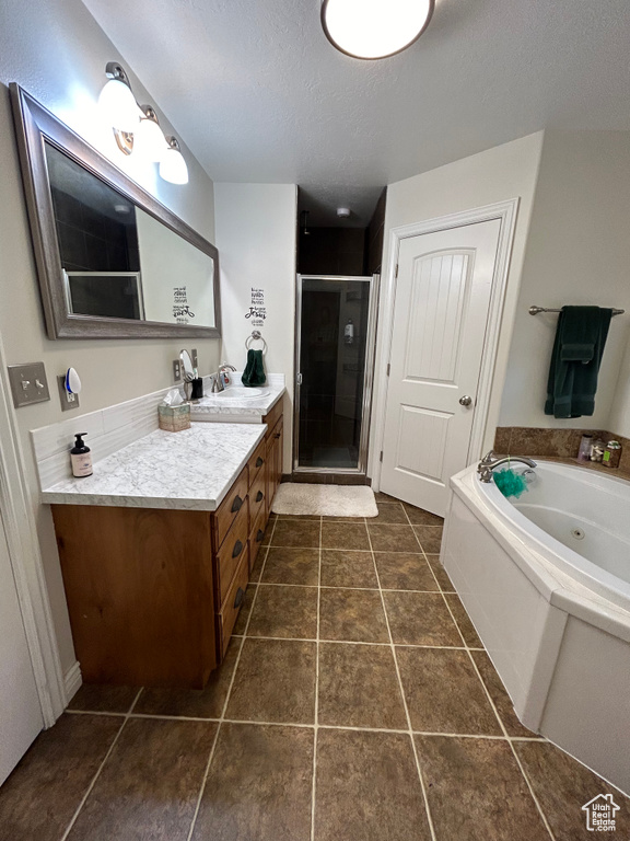 Bathroom featuring vanity, tile patterned floors, a textured ceiling, and shower with separate bathtub