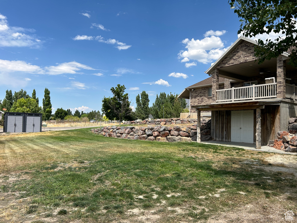 View of yard featuring a storage shed and ceiling fan