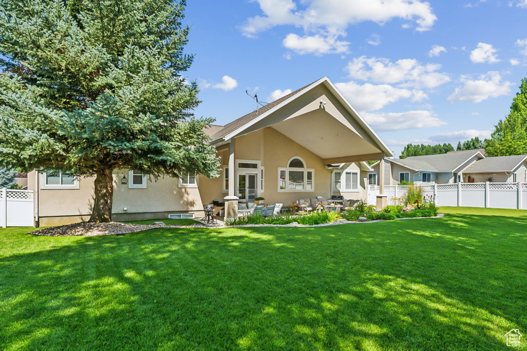 Rear view of property with a patio and a yard