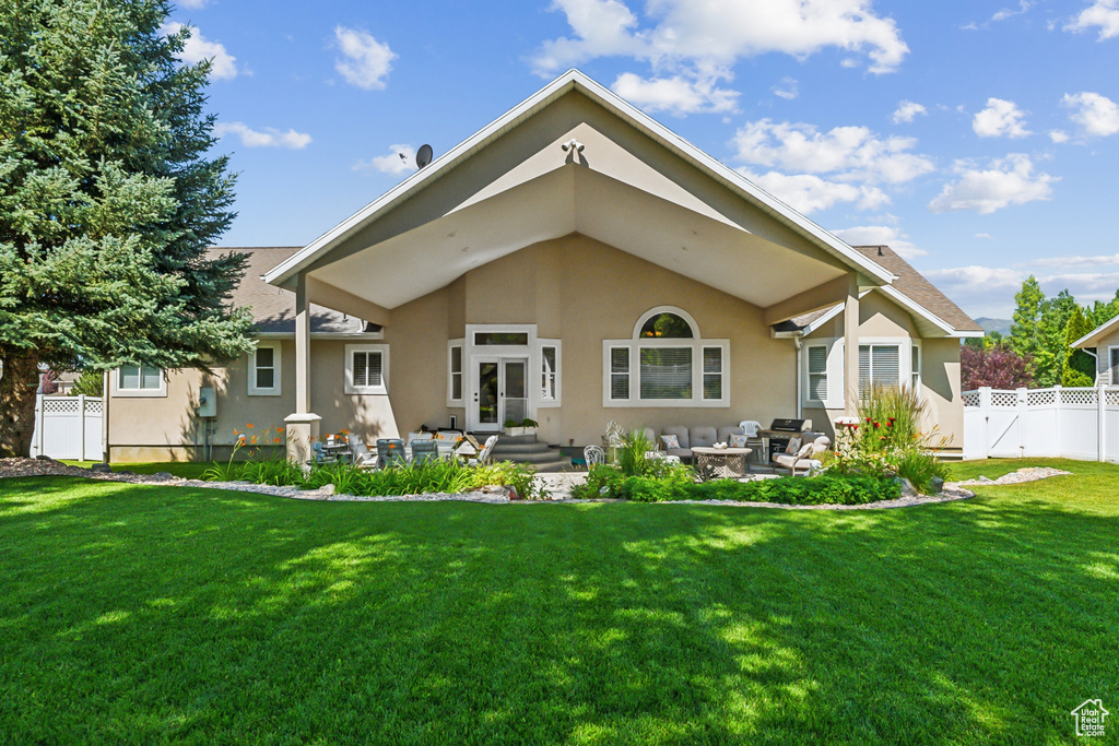 Rear view of property with a yard