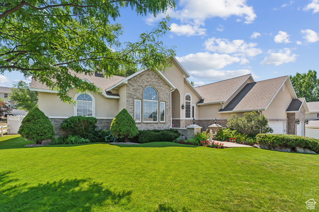 View of front facade with a garage and a front lawn