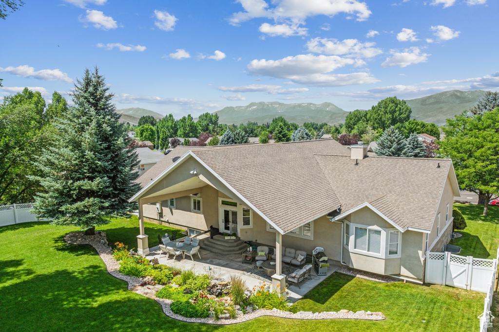 View of front of property featuring a mountain view, a patio area, and a front lawn