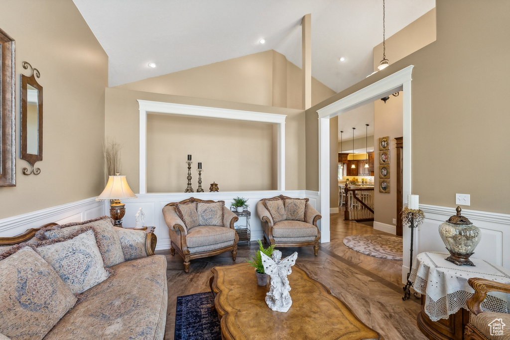 Living room with wood-type flooring and high vaulted ceiling