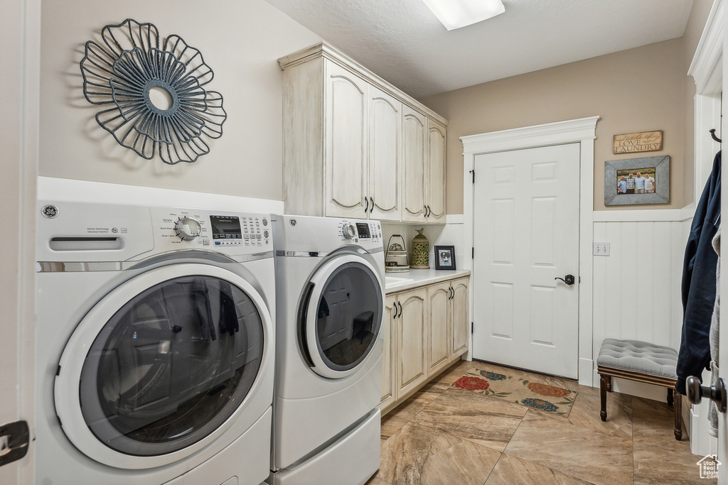 Laundry room featuring cabinets, separate washer and dryer, and light tile patterned flooring