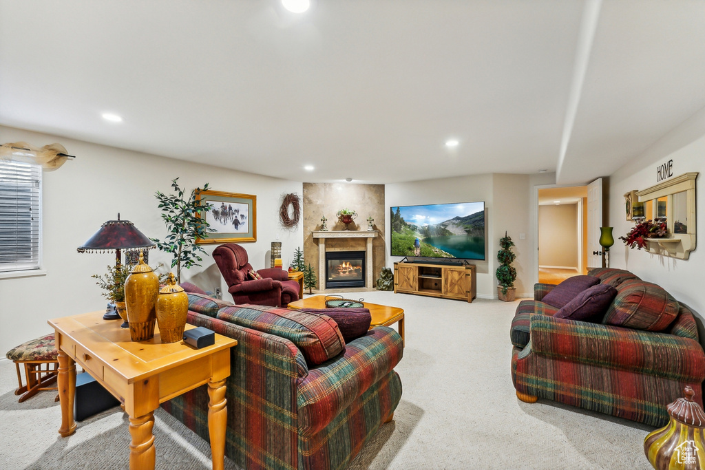 Living room featuring a large fireplace and light colored carpet