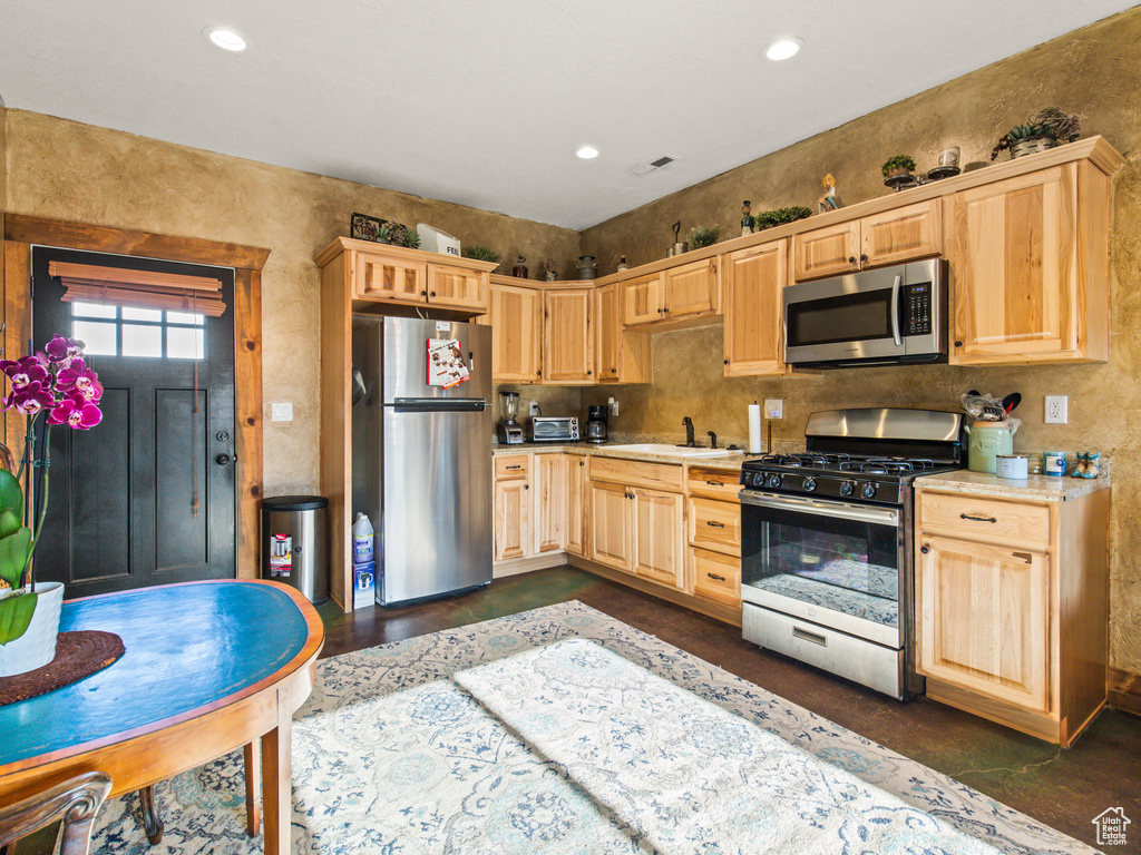 Kitchen featuring sink, light brown cabinetry, and stainless steel appliances