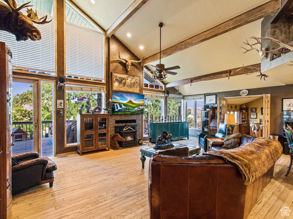 Living room featuring ceiling fan, light hardwood / wood-style floors, a wealth of natural light, and high vaulted ceiling