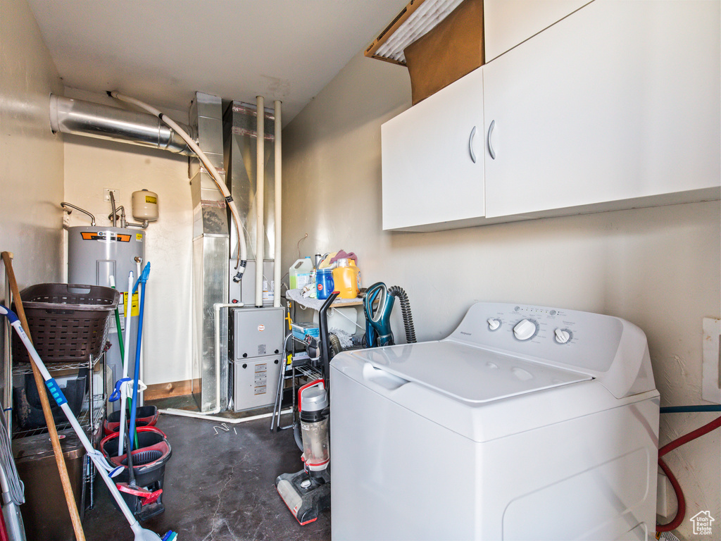 Washroom featuring washer / clothes dryer, cabinets, heating unit, and electric water heater