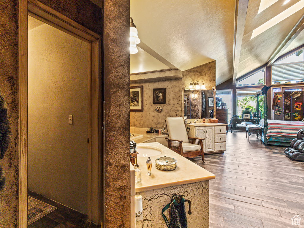 Bathroom with lofted ceiling, wood-type flooring, and vanity