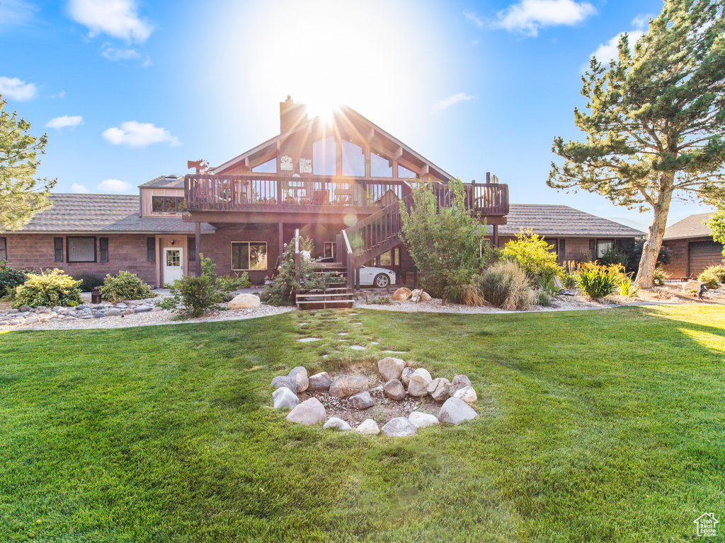 Rear view of property featuring a wooden deck and a yard