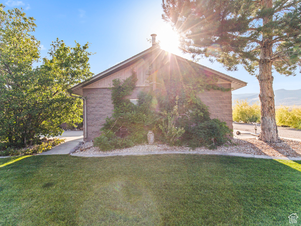 View of side of property with a lawn