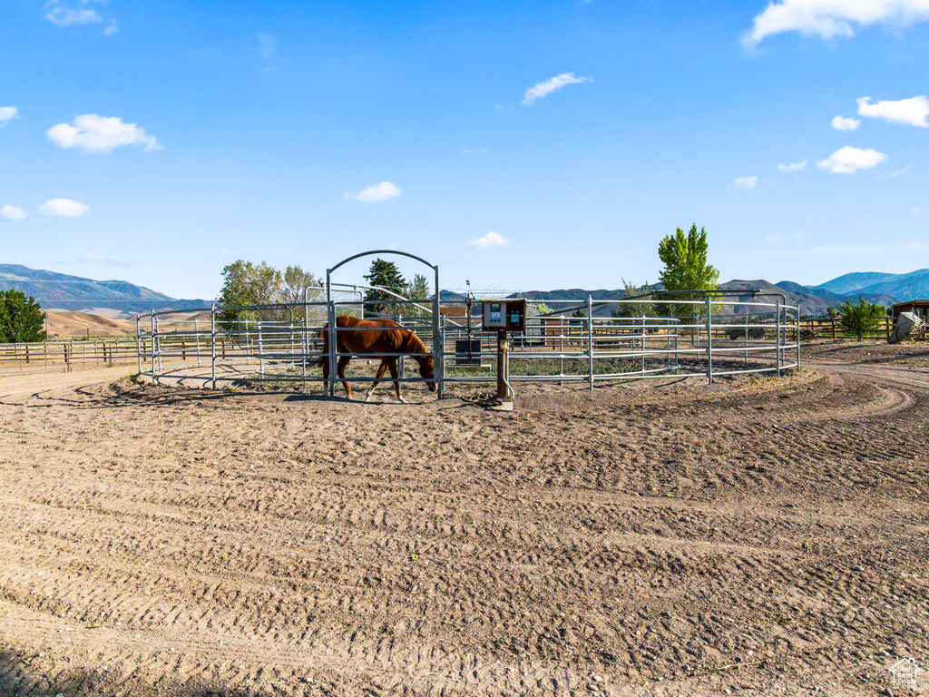 View of jungle gym featuring an outdoor structure, a mountain view, and a rural view