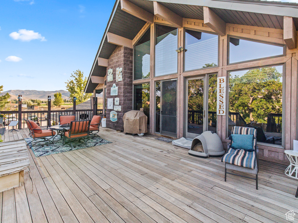 Wooden deck featuring a mountain view and a grill