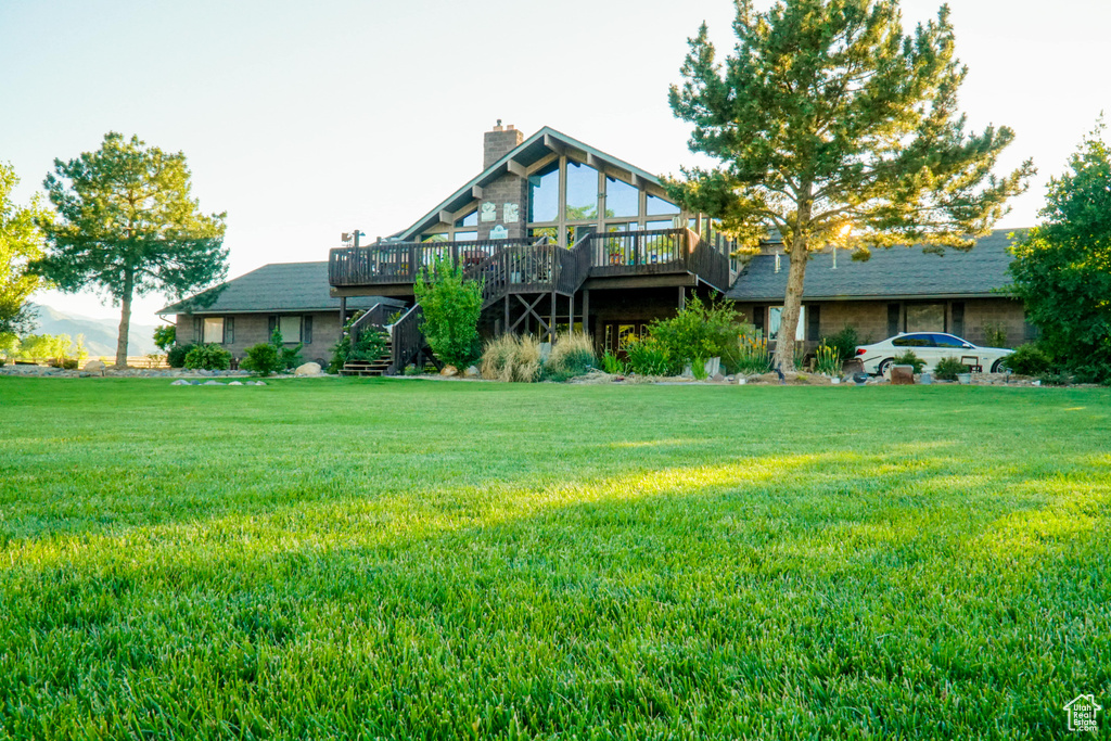 Rear view of property with a wooden deck and a lawn