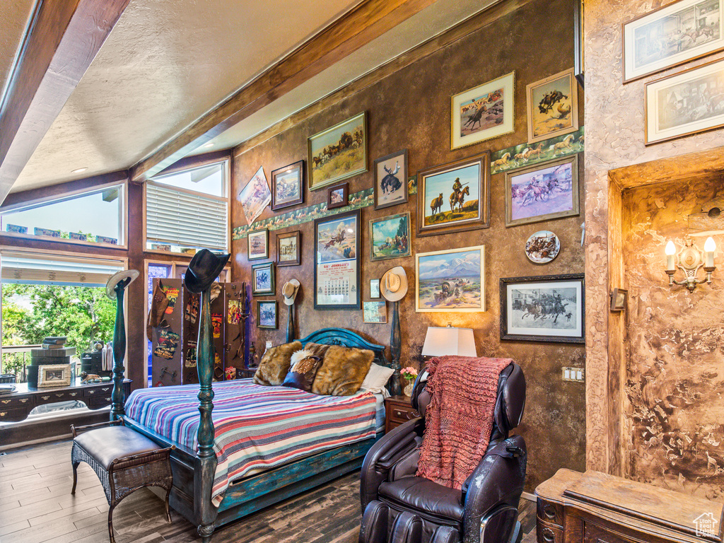 Bedroom featuring lofted ceiling, wood-type flooring, and a textured ceiling