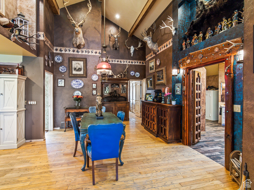 Bar with light hardwood / wood-style flooring and high vaulted ceiling