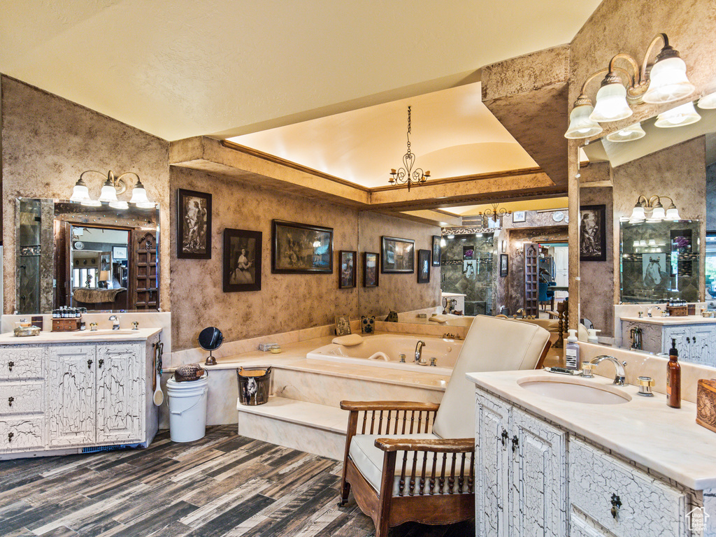 Bathroom with vaulted ceiling, a bathing tub, and double vanity