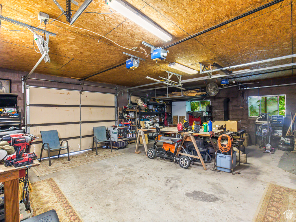 Garage featuring a garage door opener and a workshop area