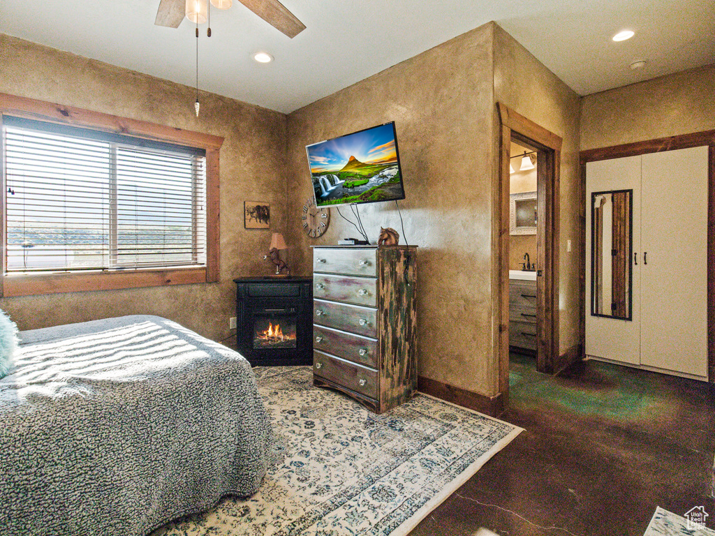 Bedroom with sink, ceiling fan, and connected bathroom