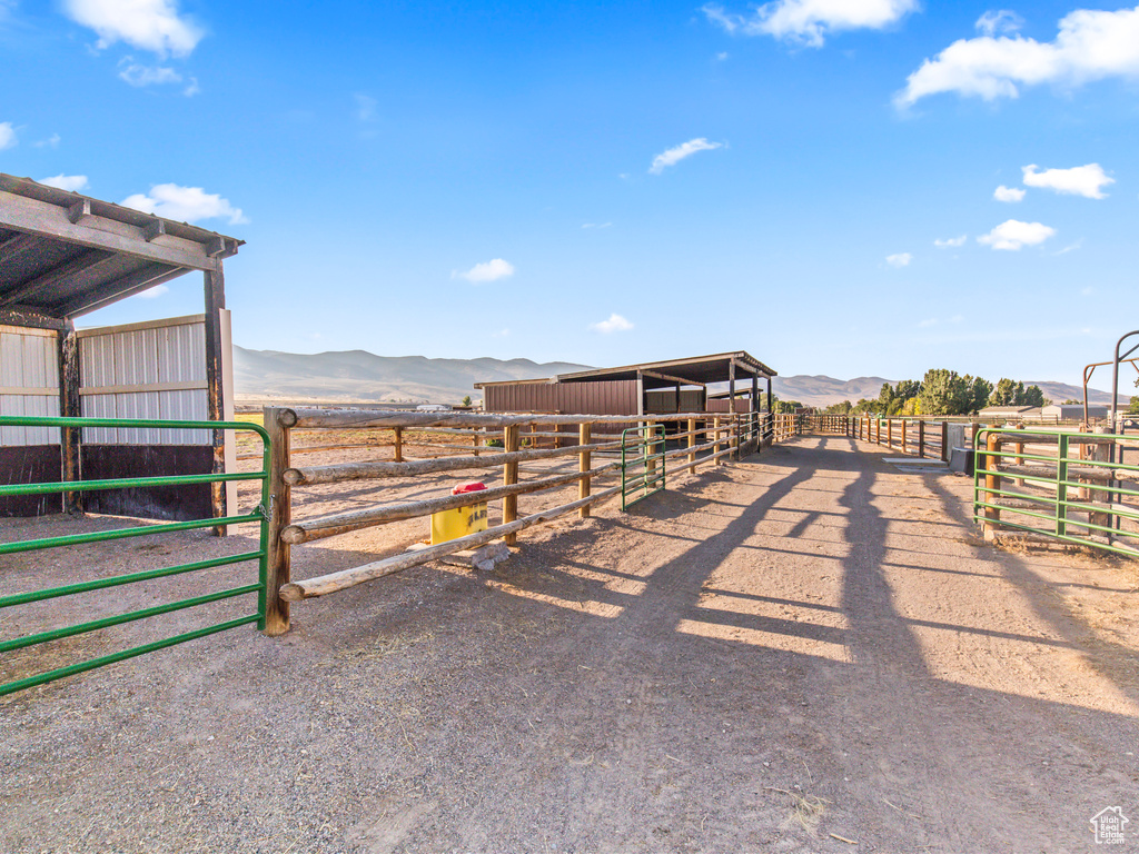 View of horse barn featuring a mountain view, a rural view, and an outbuilding