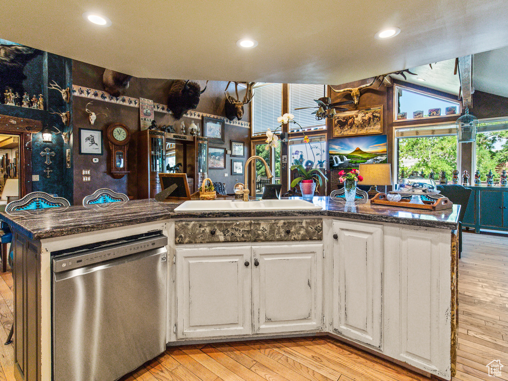 Kitchen featuring white cabinetry, dishwasher, light wood-type flooring, and sink