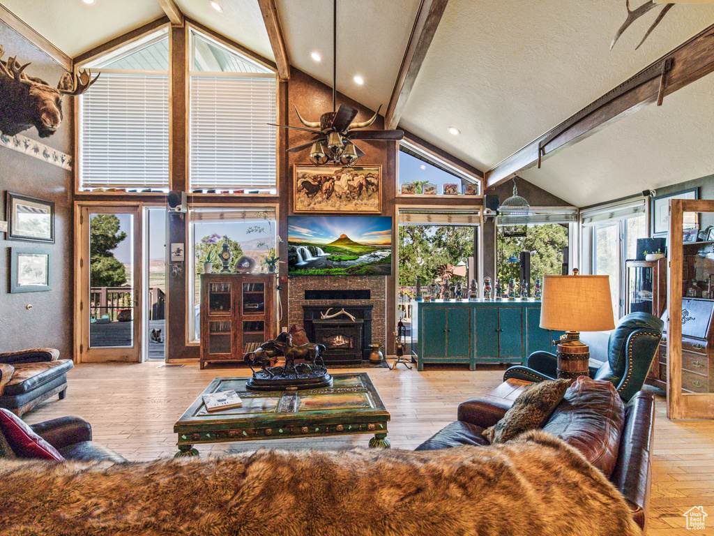 Living room featuring light hardwood / wood-style floors, beamed ceiling, and high vaulted ceiling