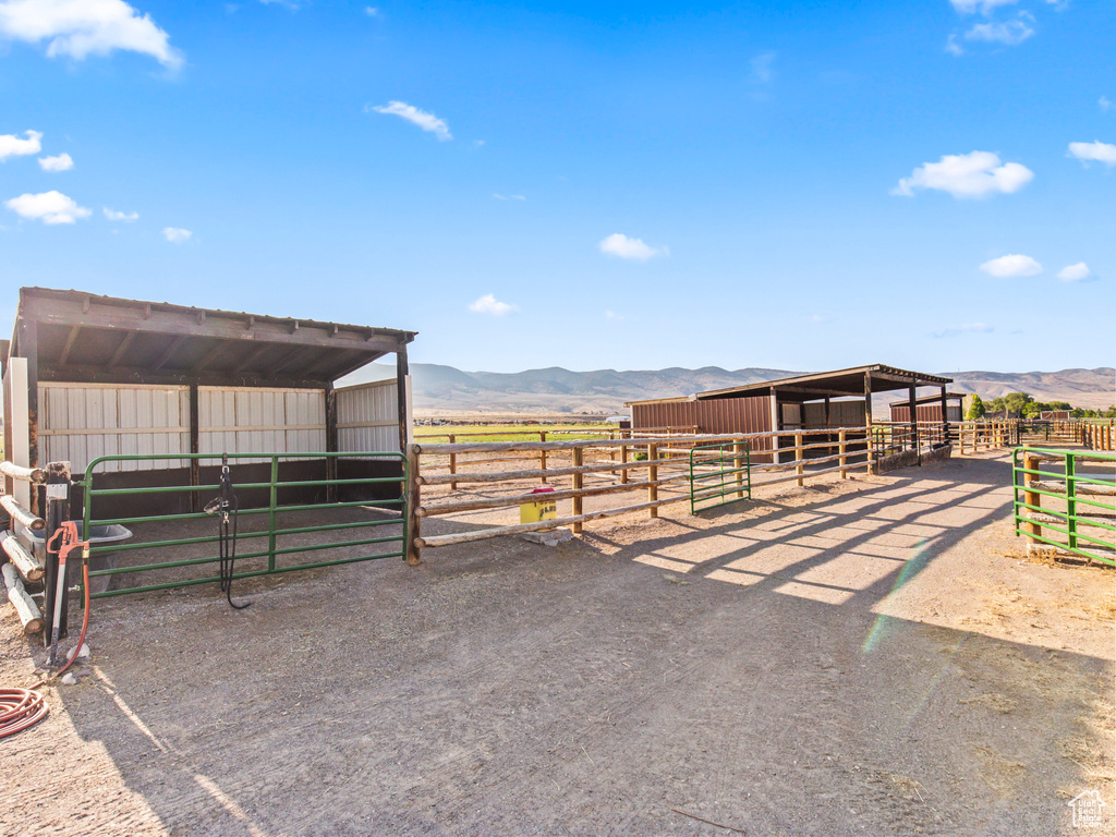 View of horse barn with a mountain view, an outbuilding, and a rural view