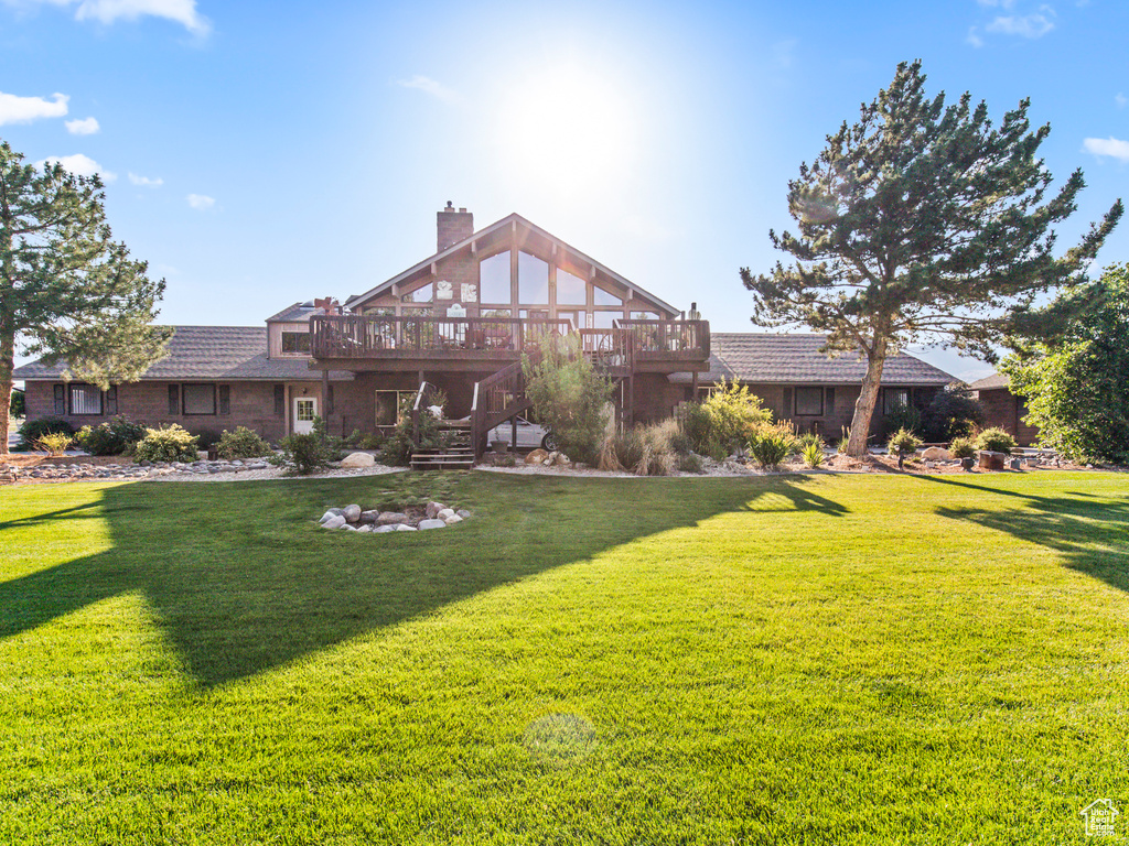 Rear view of house featuring a yard and a wooden deck