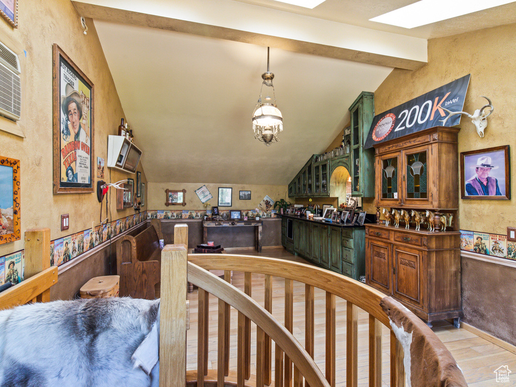 Interior space featuring lofted ceiling with beams, an inviting chandelier, and light hardwood / wood-style floors