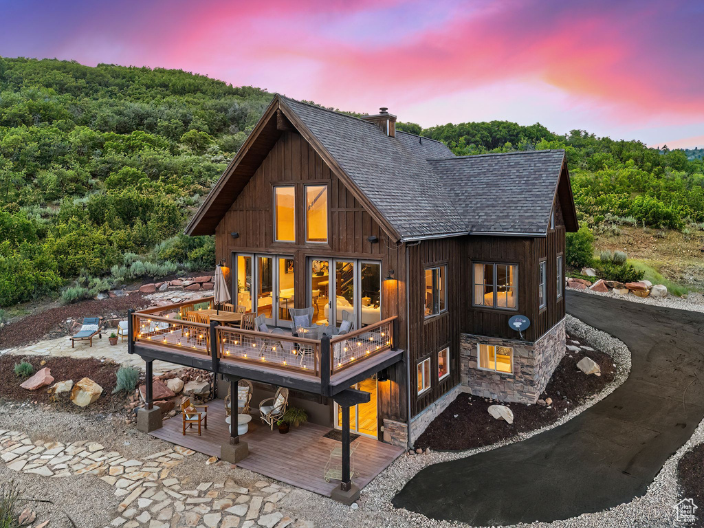 Back house at dusk featuring a wooden deck