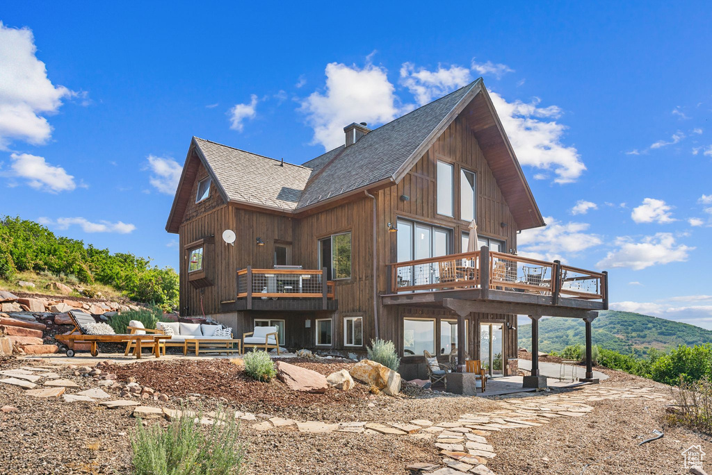 Back of property featuring a patio and an outdoor hangout area